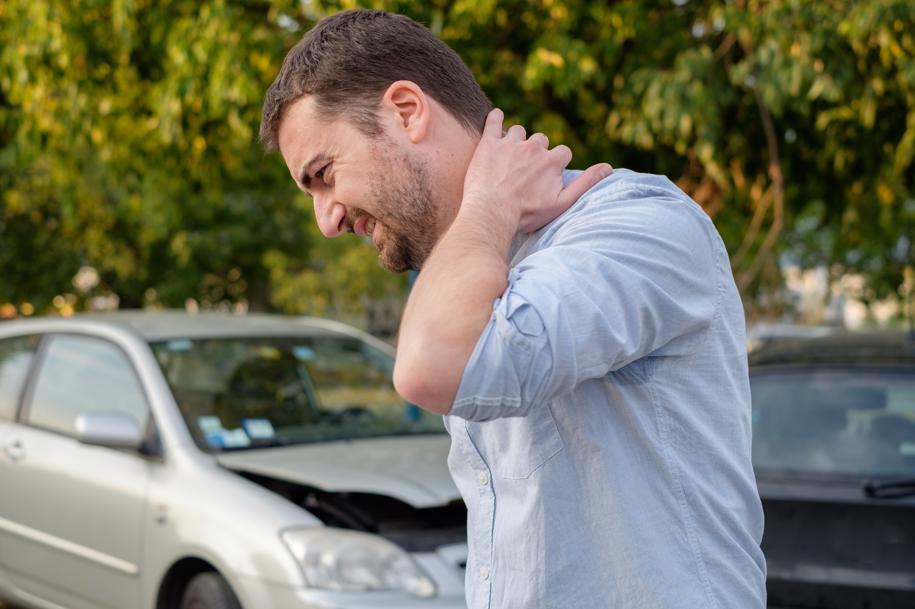 a man holding his neck after a car accident.